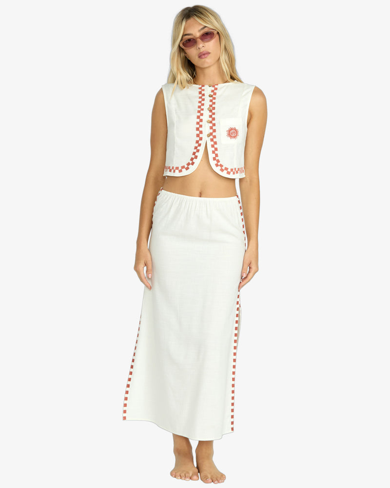 Cream sleeveless crop top with red trim and embroidered sun logo on left chest.