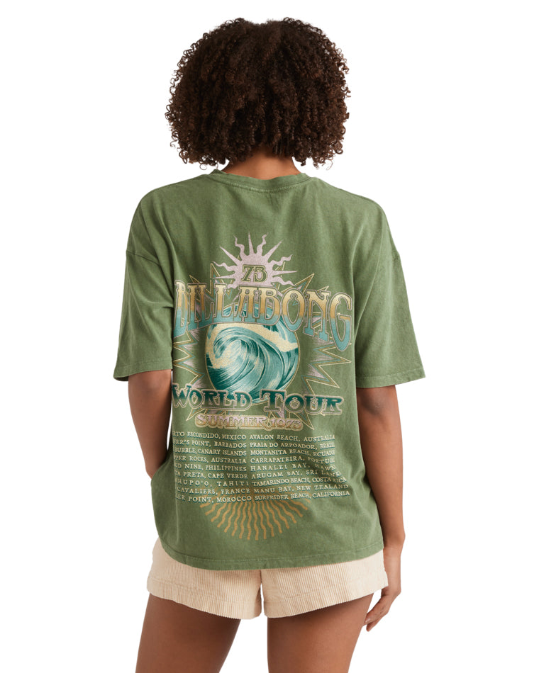Back view of green t-shirt with large Billabong World Tour 1973 wave graphic.green t-shirt with large Billabong World Tour 197