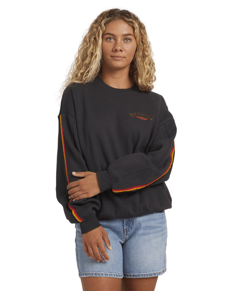 Black Billabong crewneck with red and yellow stripe on sleeve and logo on chest, worn with denim shorts