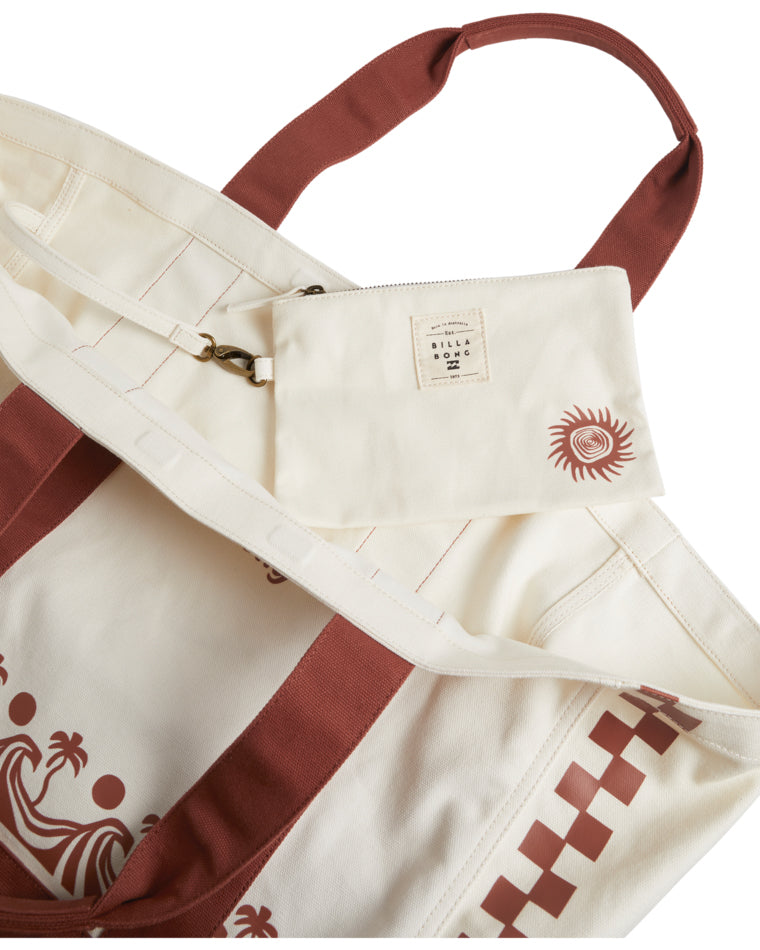 Inside view of the tote bag revealing a detachable cream pouch with sun graphic and label tag.