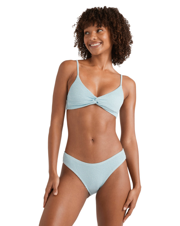 Woman wearing a textured light blue bikini top with thin adjustable straps and a front twist detail.