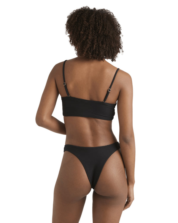 Back view of woman in a black bandeau bikini, showing adjustable straps and cheeky cut bottoms.