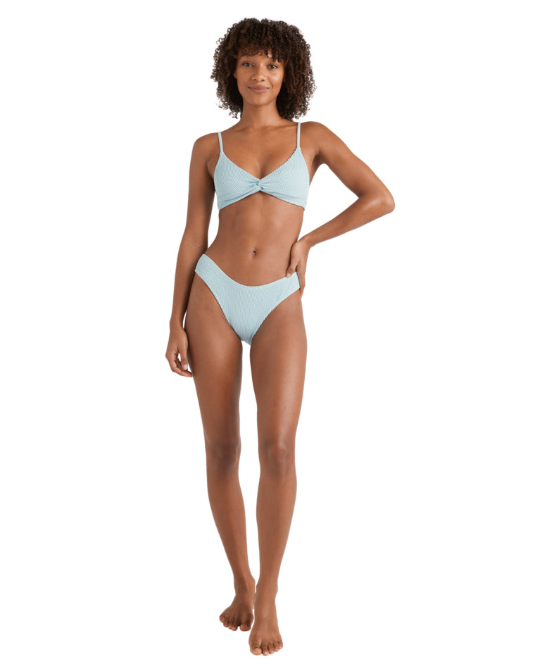 Full body front view of the model in the pale blue textured twist bikini set, standing relaxed.