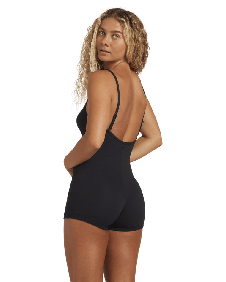 Back view of a black fitted playsuit with open back and thin straps.