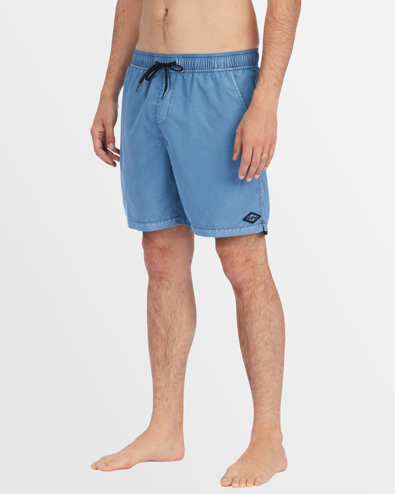 Side view of blue elastic waist boardshorts with subtle curved hem.