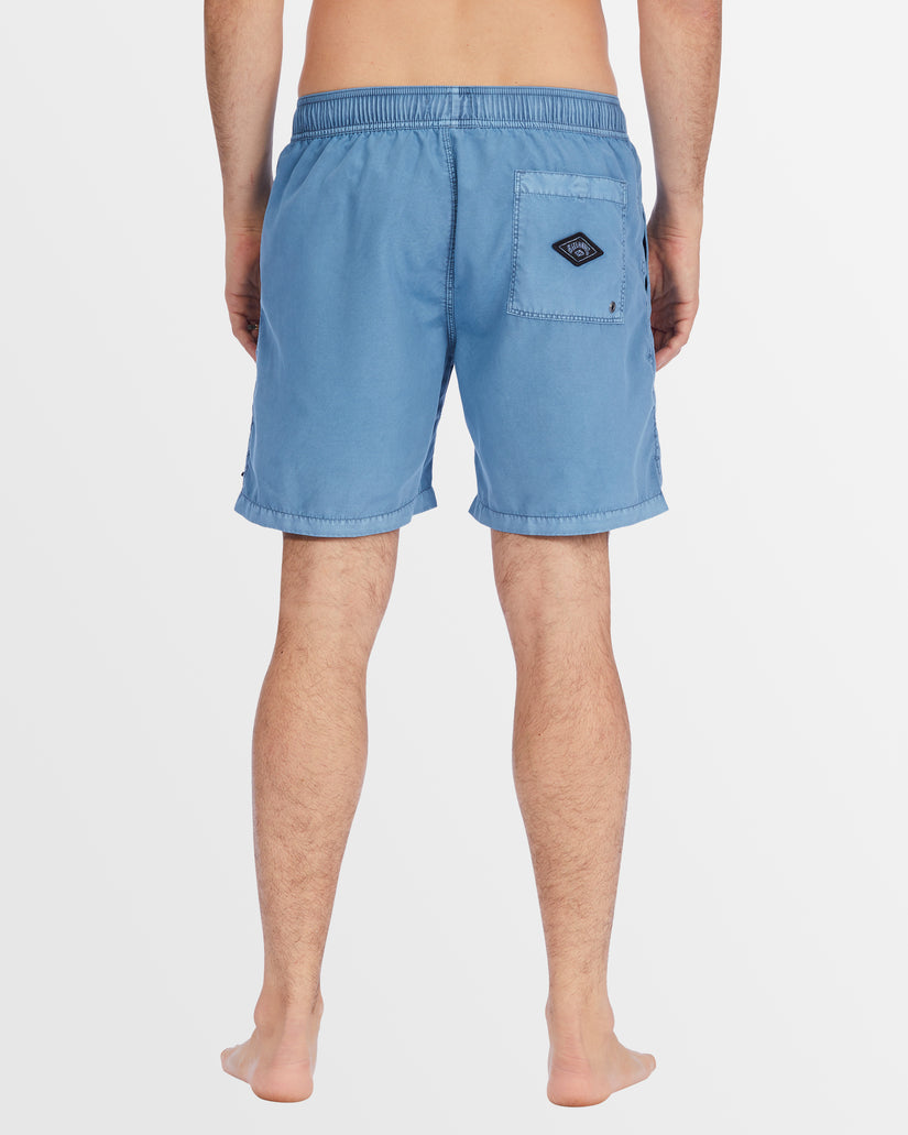 Back view of blue boardshorts with patch pocket and Billabong logo.
