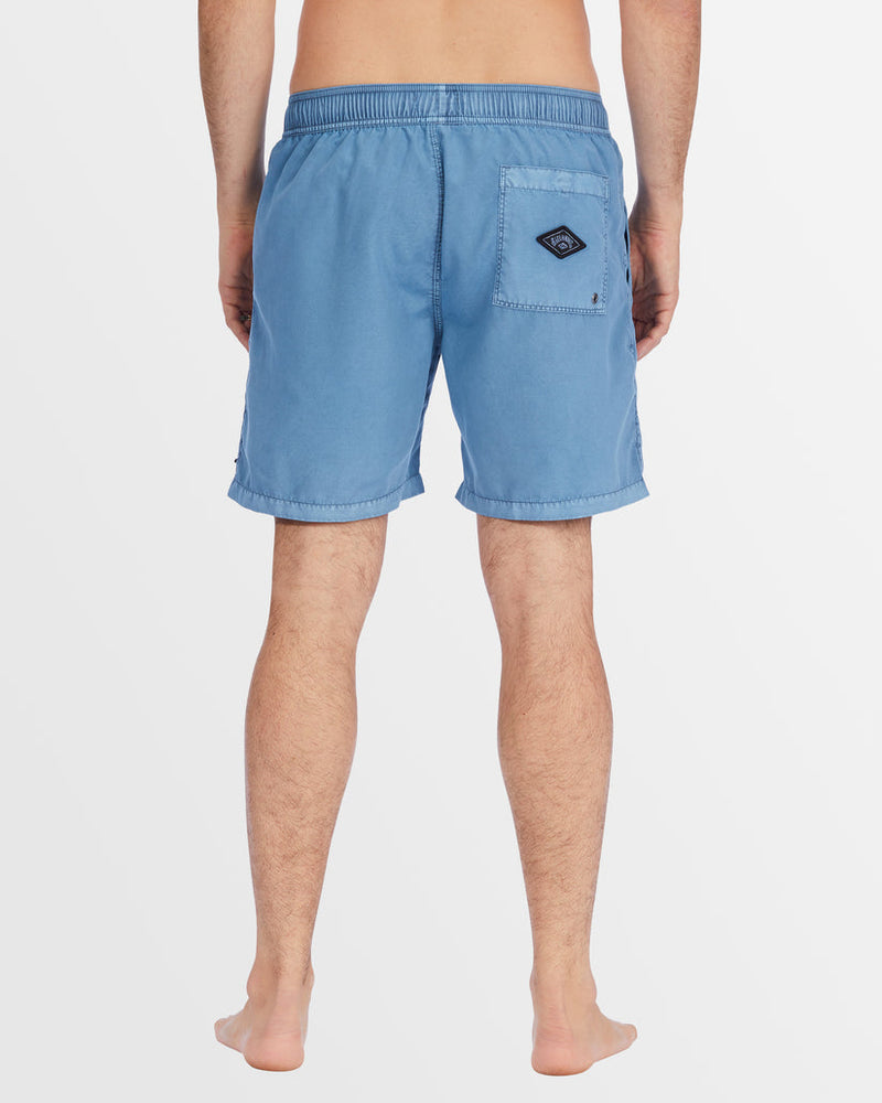 Back view of blue boardshorts with patch pocket and Billabong logo.
