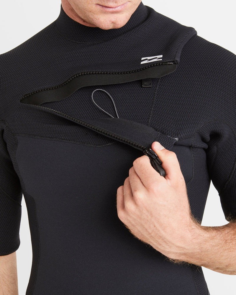 Front chest zip on black Billabong wetsuit being unzipped by model.