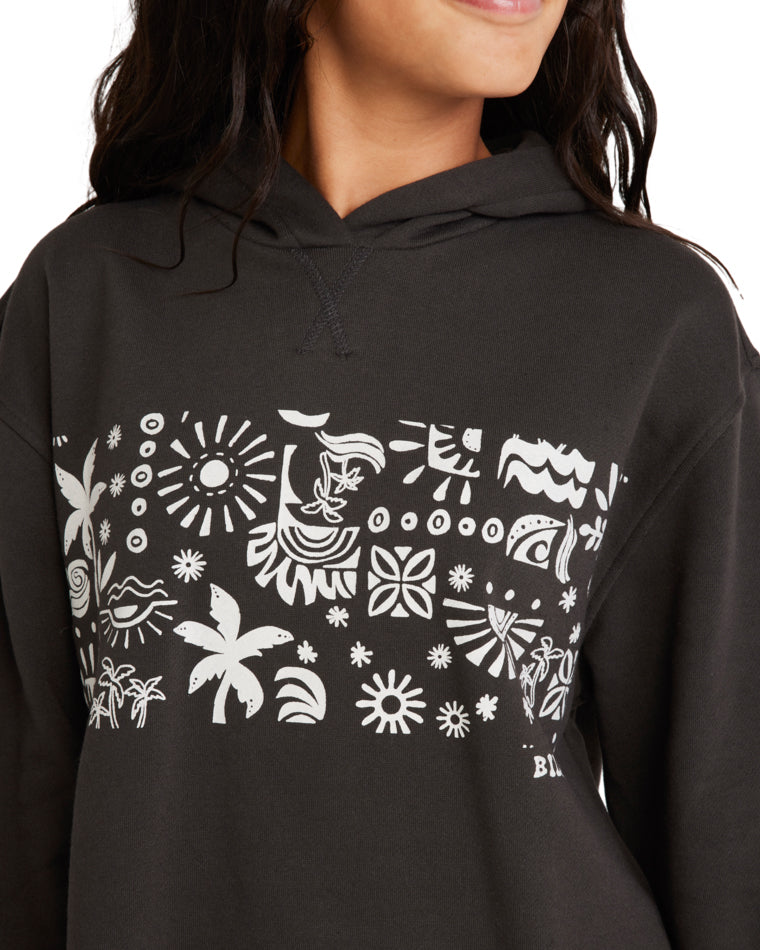 Close-up of a woman wearing a black Billabong hoodie featuring a white tropical-inspired graphic print on the front.