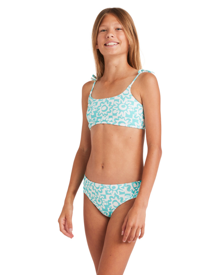 Girl in a turquoise and white floral print bikini, shown from a side angle.