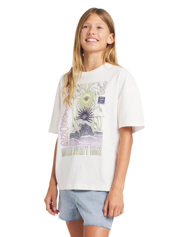 Side angle of the girl wearing an oversized Billabong graphic t-shirt with light-wash denim shorts.