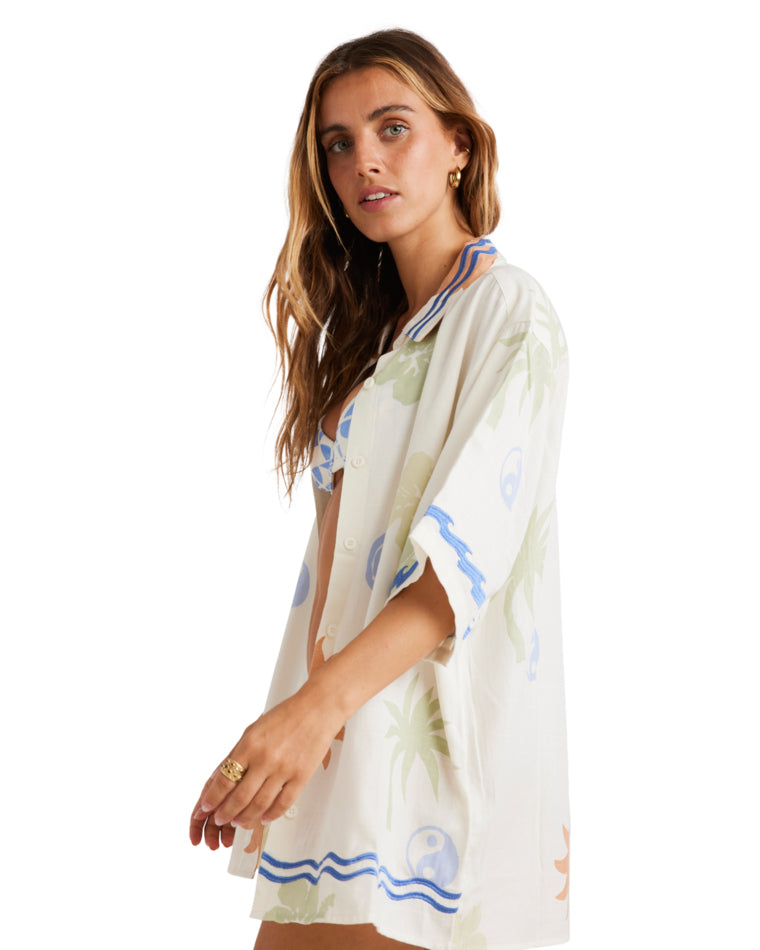 Side view of an oversized white button-up shirt with colorful tropical prints and blue trim, styled with a relaxed fit.