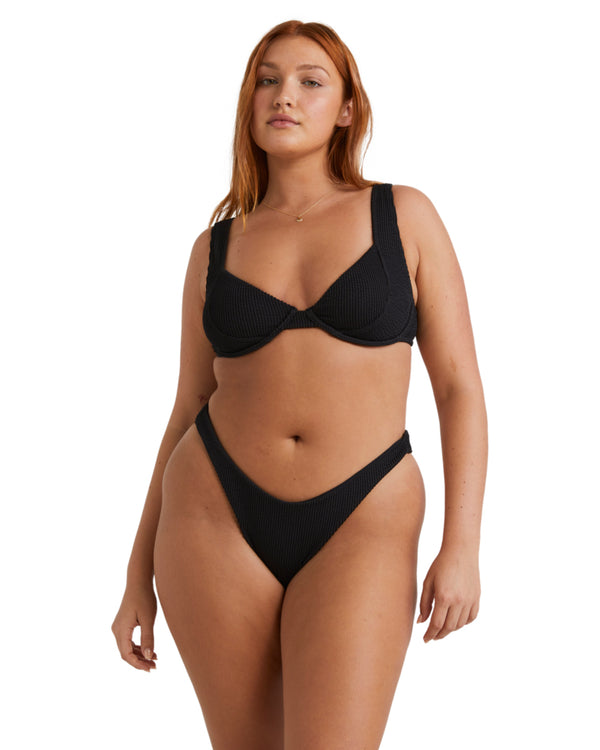 Front view of a woman wearing black textured underwire bikini with wide straps.