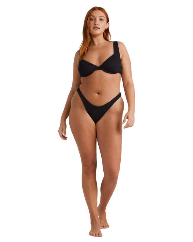 Full body front view of woman in black underwire bikini set.