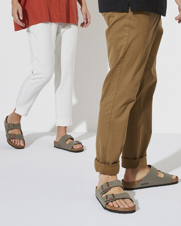 Birkenstock slides worn by models, styled with casual outfits featuring white pants, tan chinos, and relaxed tops.