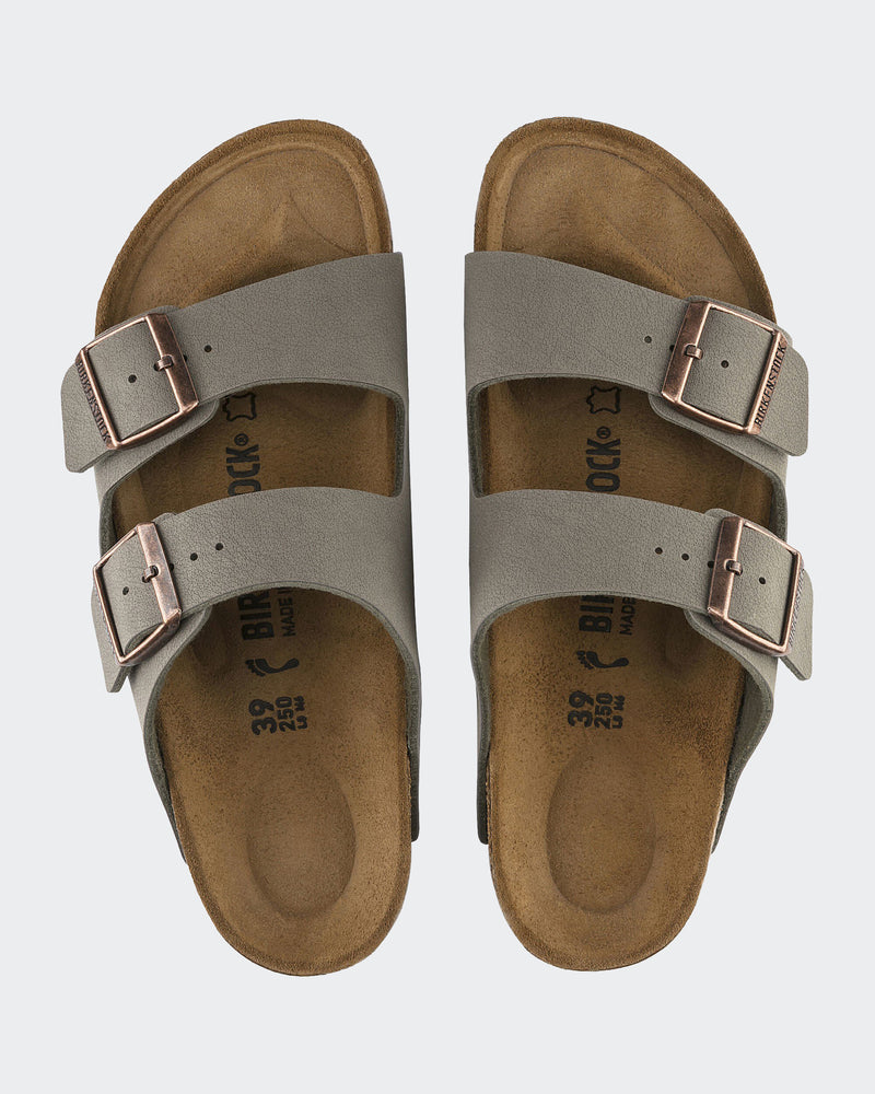 Top view of Birkenstock slides featuring gray suede straps, metallic buckles, and a contoured cork footbed for added comfort.