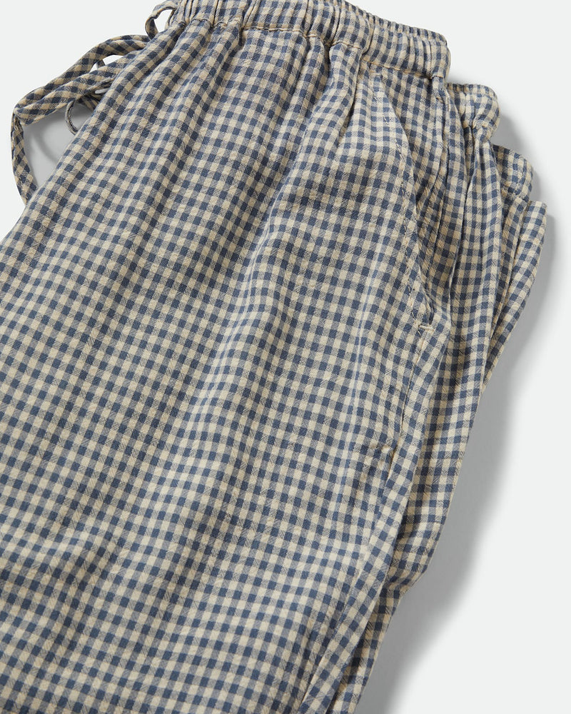 Close-up of soft gingham fabric pants featuring an elastic drawstring waistband, showcasing the lightweight and textured material.