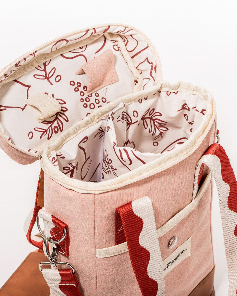 Open pink wine cooler tote bag with insulated interior, wine-themed lining, bottle dividers, and red wave-pattern strap.