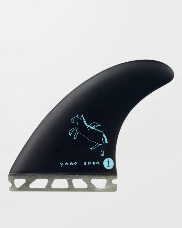 Black single surfboard fin with light blue Pegasus graphic and Yago Dora signature on the side.