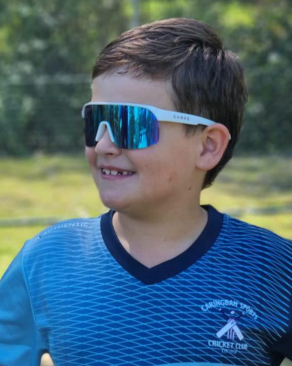 Boy wearing white Carve sunglasses with reflective blue lens.
