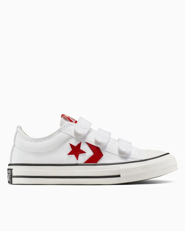 White Converse kids' sneakers with red star and chevron, side profile showing velcro straps.