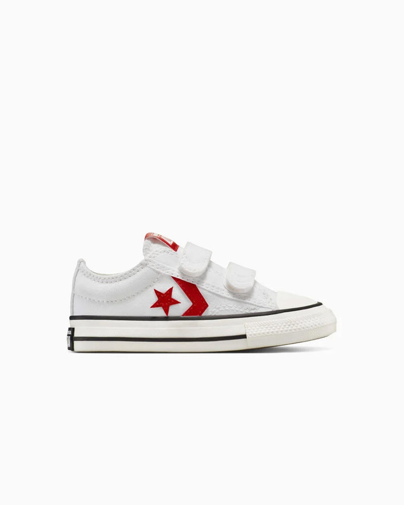 White Converse sneakers with red star logo and double velcro straps, side view.