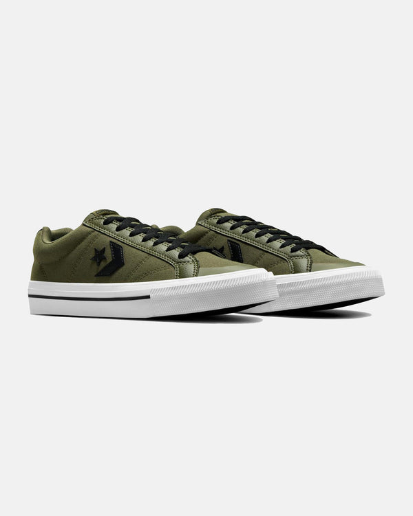 A pair of olive green low-top sneakers with black laces, black star logos, and white rubber soles featuring black stripes.