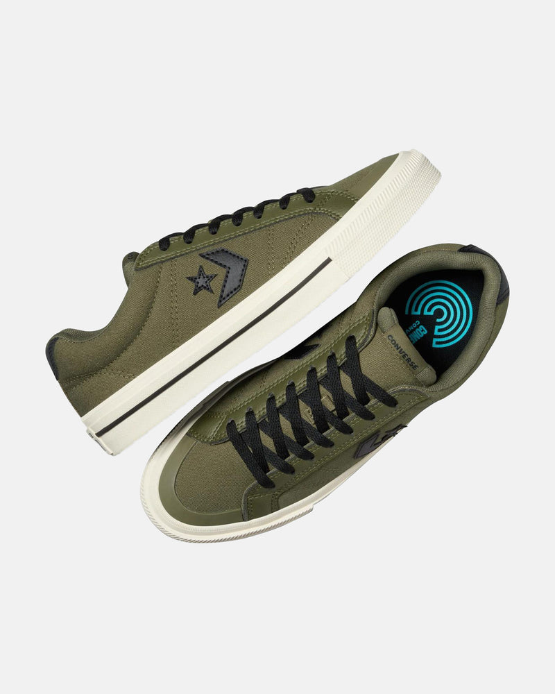 Top and side view of olive green low-top sneakers with black laces, black star logos, white soles, and a blue insole design.