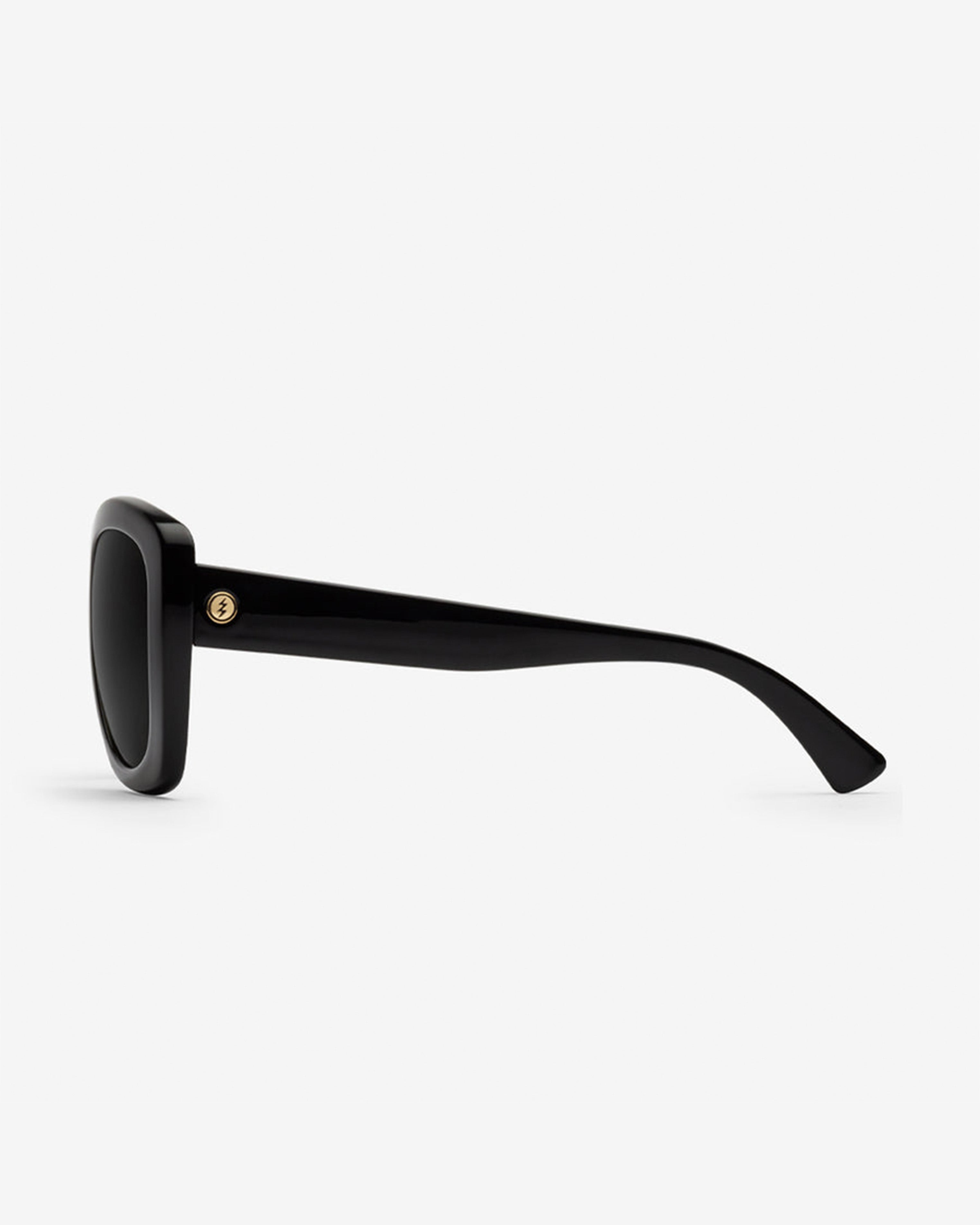 Profile view of sleek black sunglasses with wide arms and subtle gold emblem on temple.