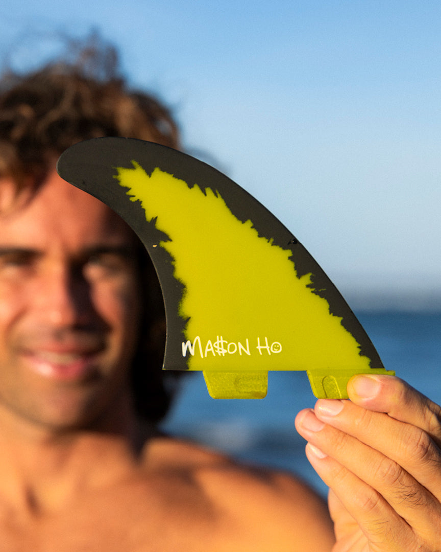 Close-up of Mason Ho fin in hand, showing yellow and black colourway and custom signature print.