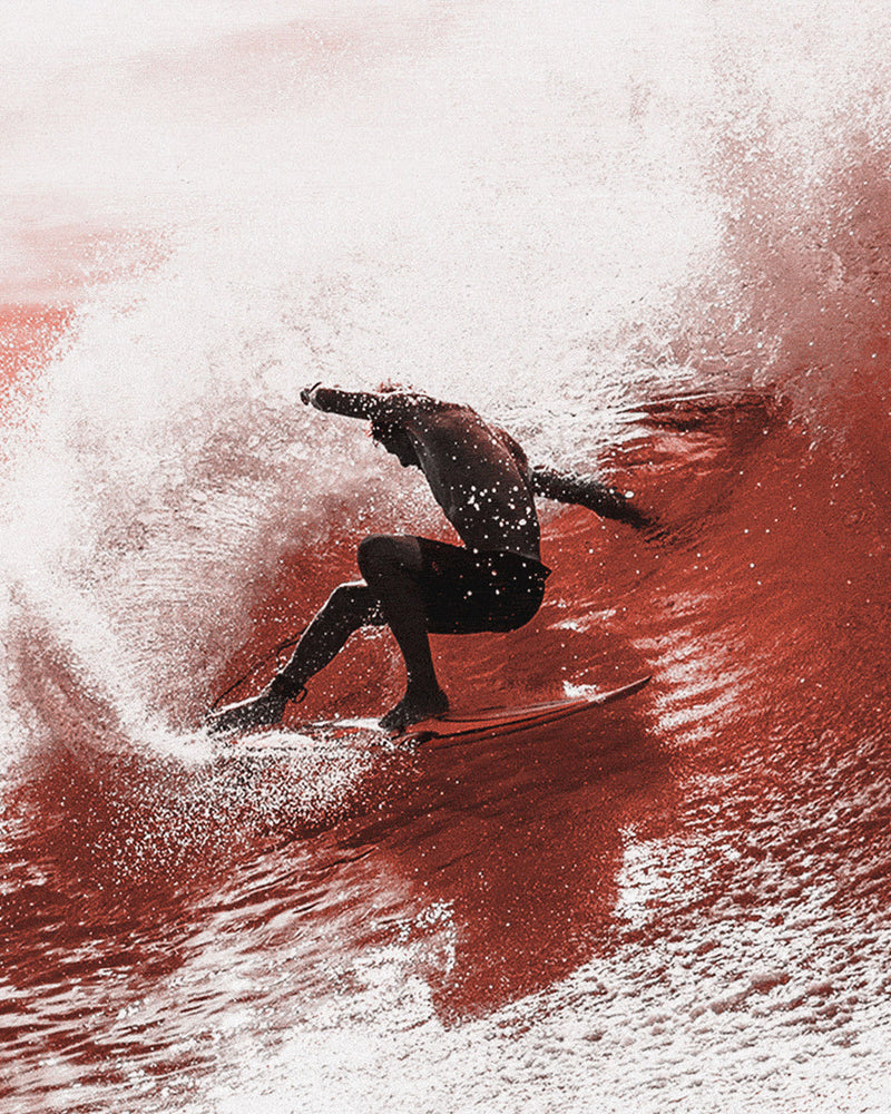 Surfer riding inside a powerful wave, showcasing fluid movement and spray in a dynamic action shot.