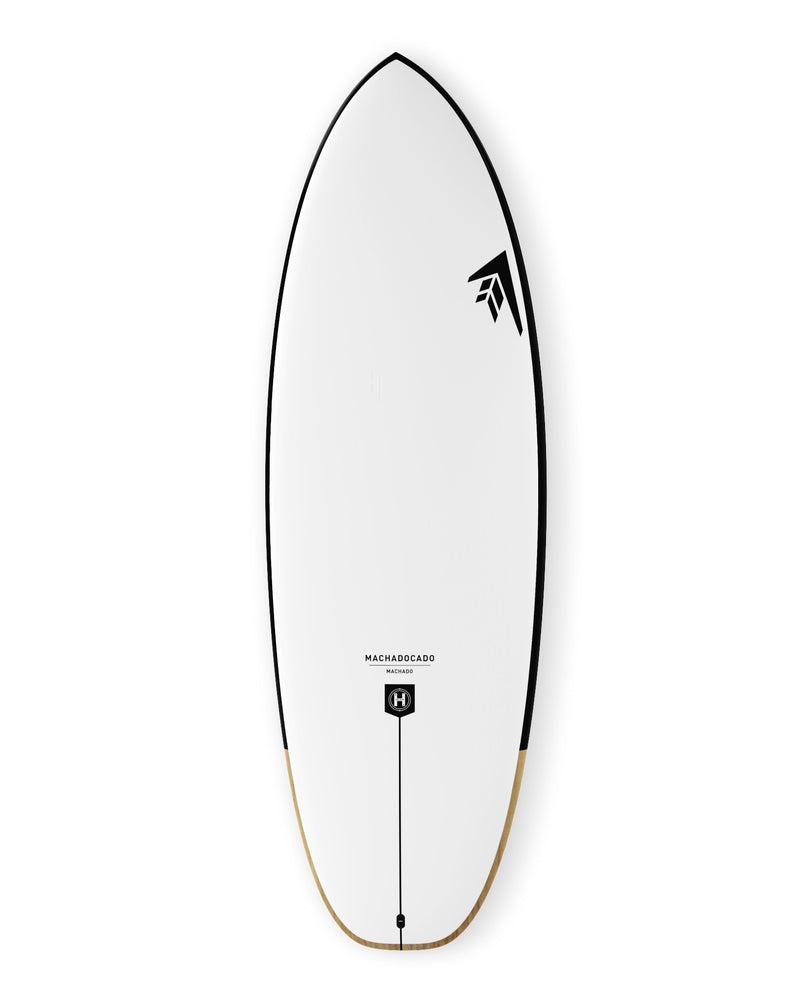 White surfboard with rounded outline, black rail trim, and Machado model label above the tail plug.