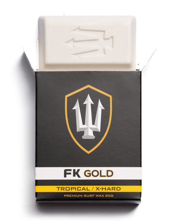 Opened box of FK Gold Tropical X-Hard surf wax showing white wax block with embossed trident logo.