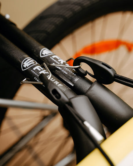 Close-up of FK Surf bike rack hardware and branding with secure bungee attachment.