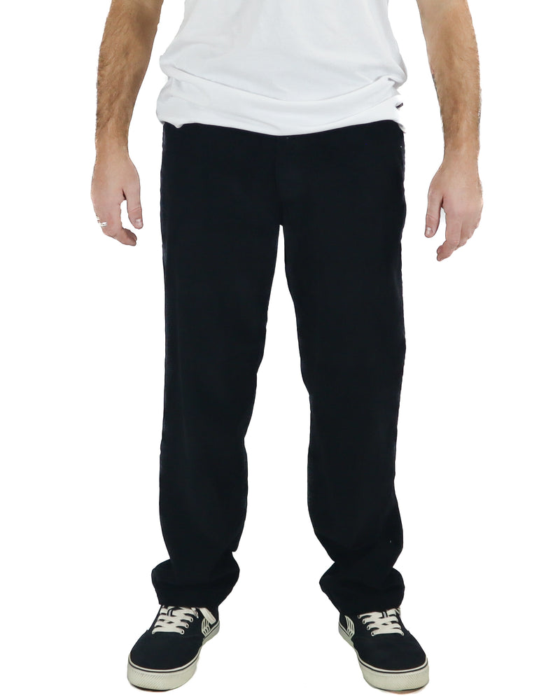 Man wearing black straight leg corduroy pants with a relaxed fit and black skate shoes