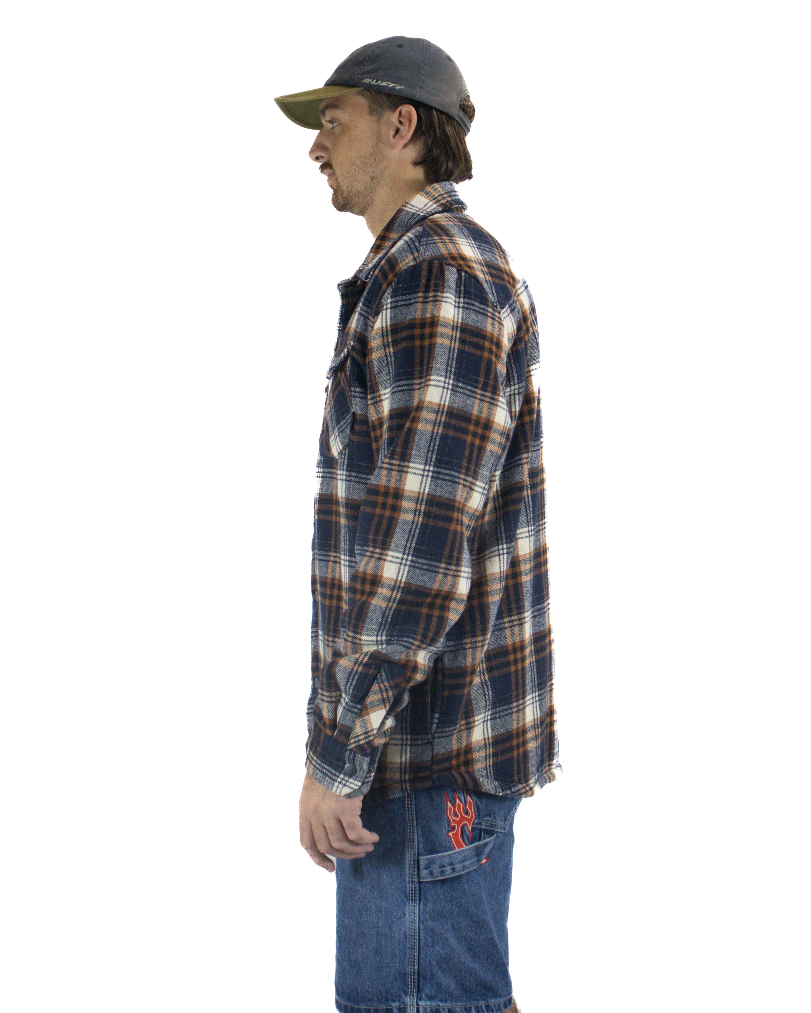 Side view of plaid flannel shirt paired with mid-wash denim shorts and a charcoal cap