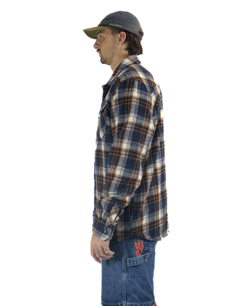 Side view of plaid flannel shirt paired with mid-wash denim shorts and a charcoal cap