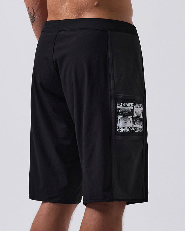 Back view of black boardshorts featuring a side pocket with a graphic print, fixed waistband, and a clean, modern design.