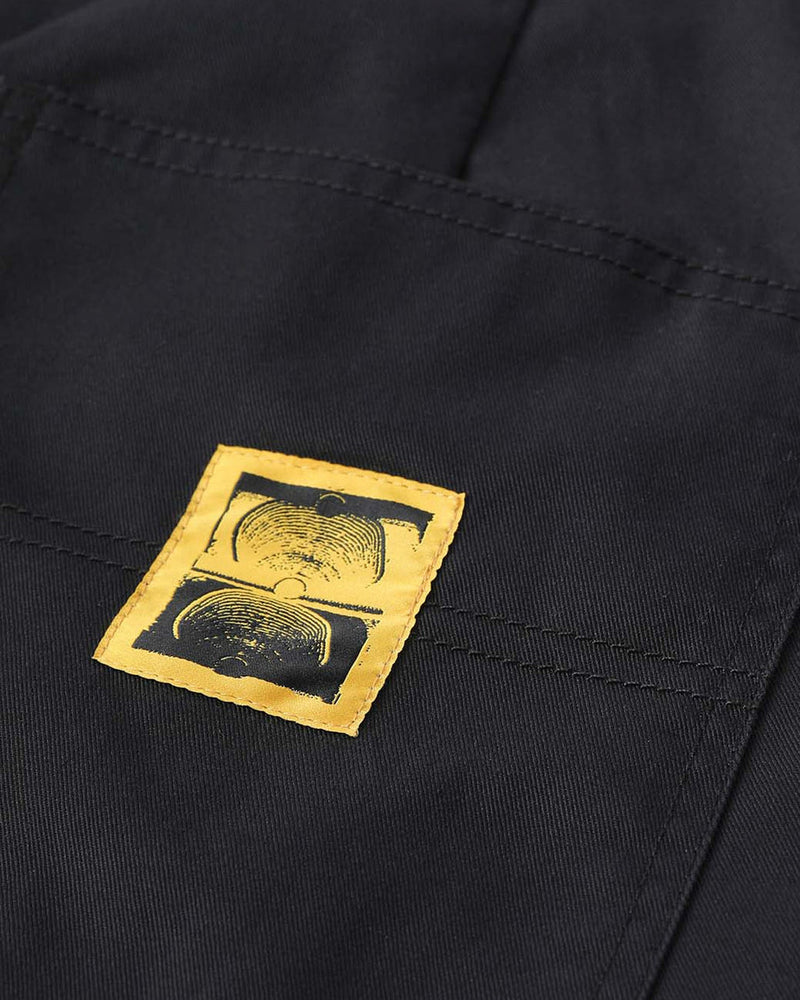 Close-up of yellow stitched logo patch on black fabric