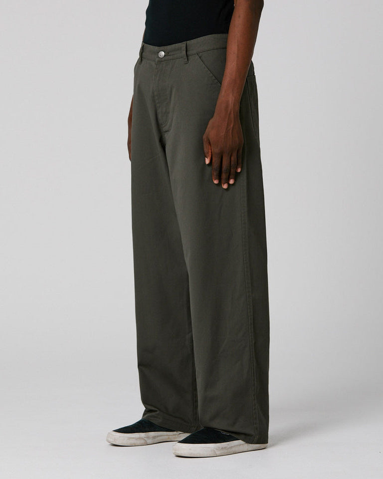 Side view of wide-leg olive pants with slanted pockets and a loose, straight-leg silhouette
