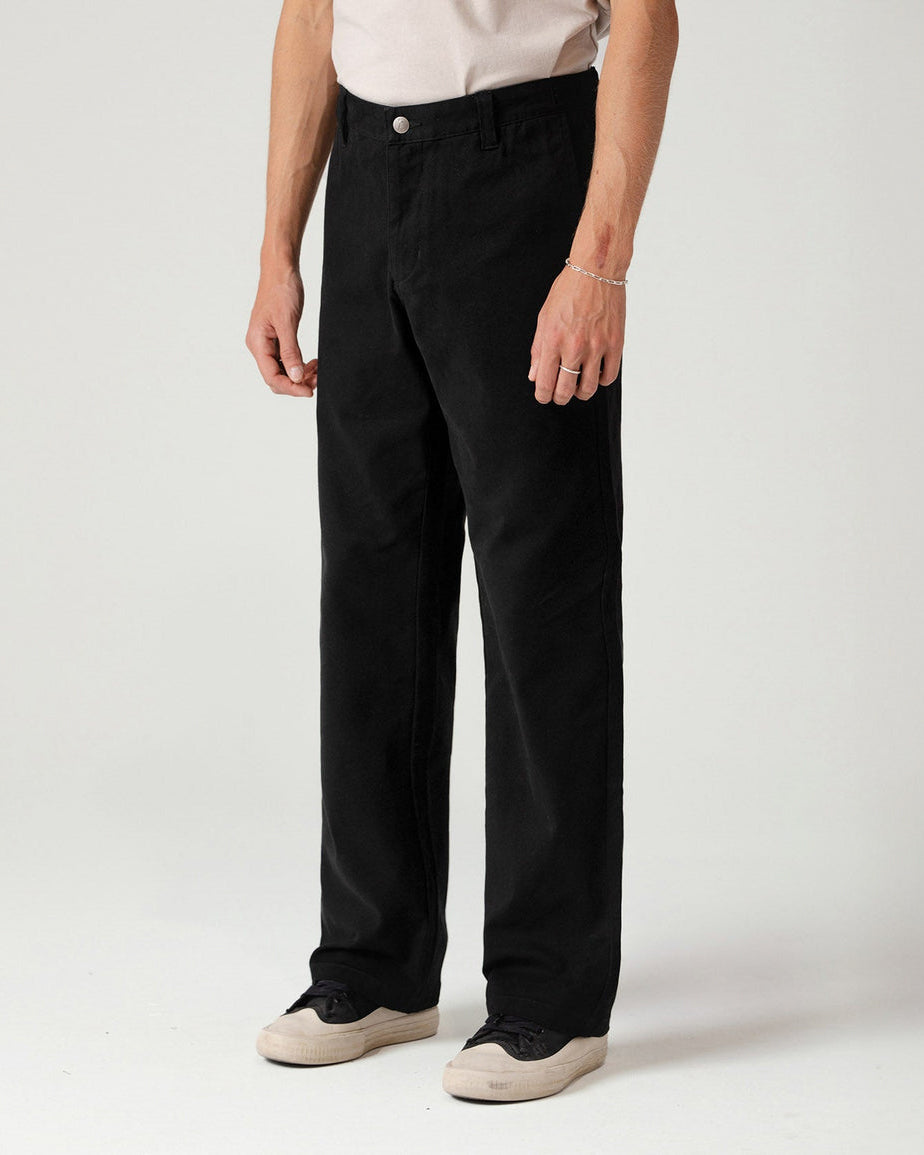 Black pants side view showing clean lines and classic fit with casual sneakers.