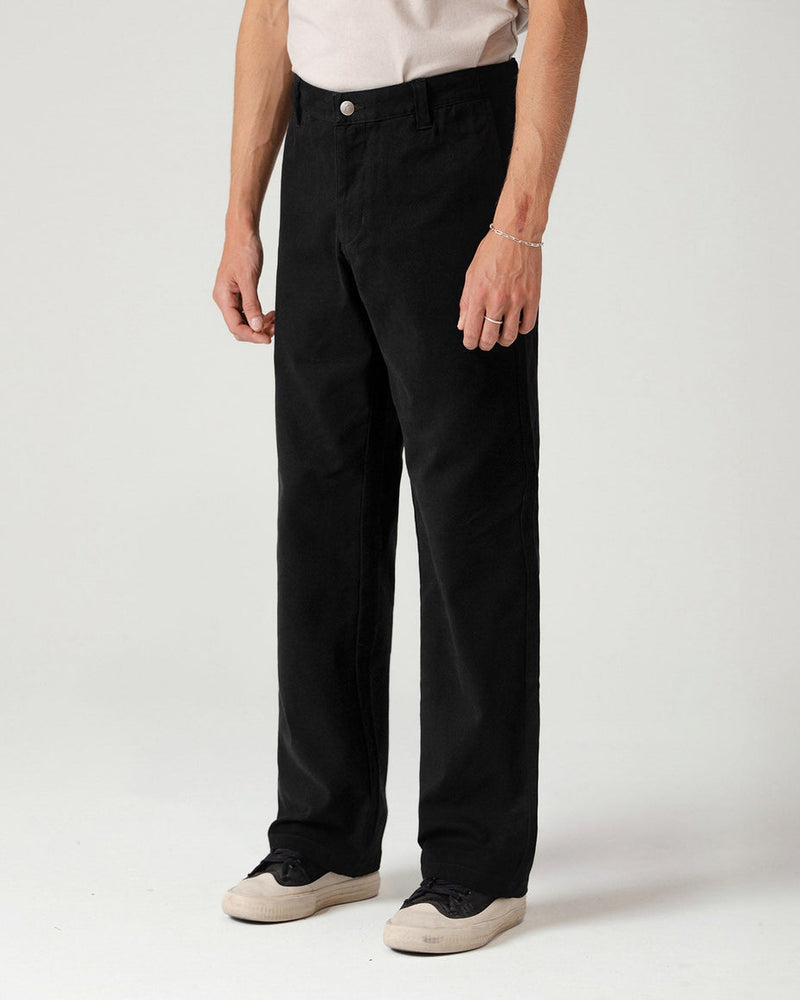 Black pants side view showing clean lines and classic fit with casual sneakers.