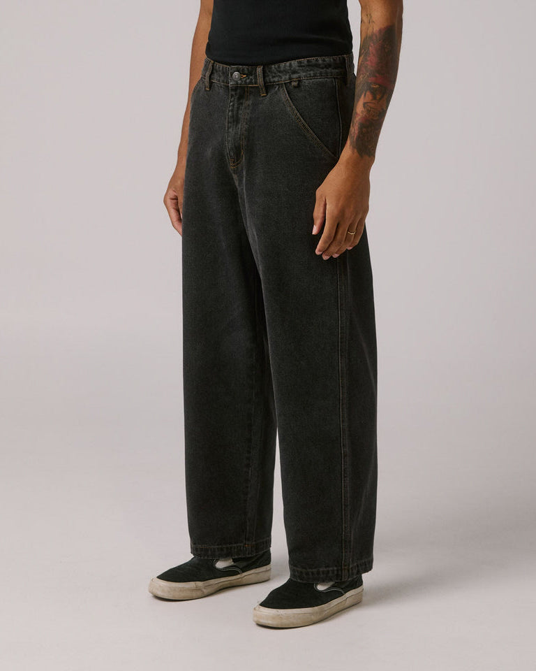 Side view of wide leg black jeans with faded wash and casual streetwear style.