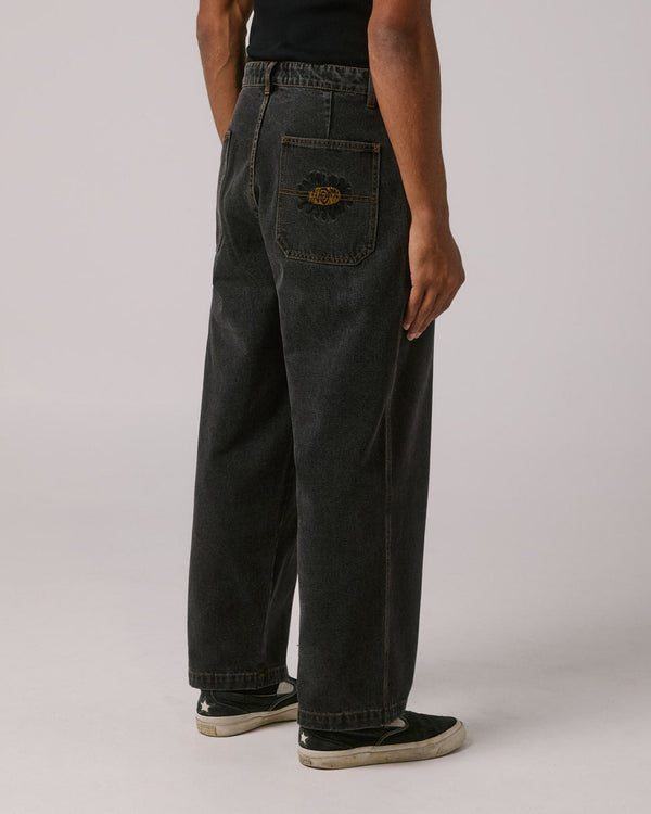 Back view of relaxed black denim jeans featuring embroidered rear pocket logo and straight leg cut.