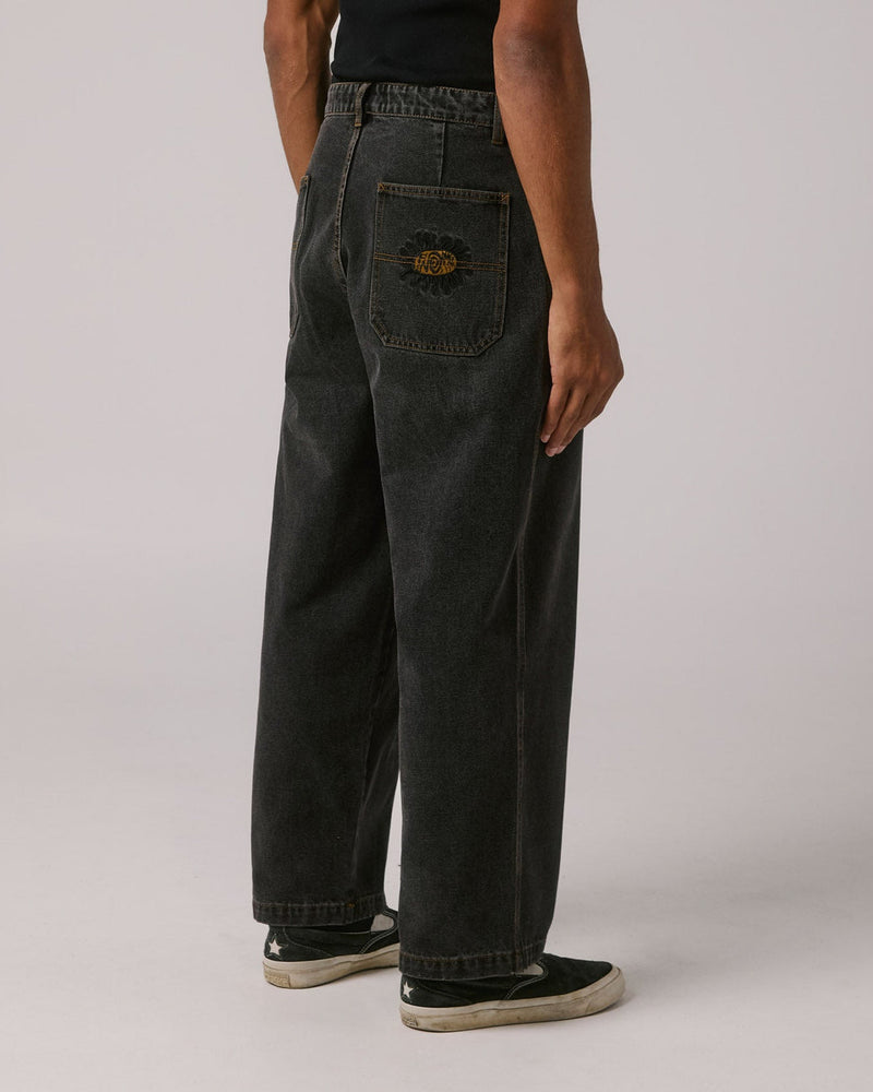 Back view of relaxed black denim jeans featuring embroidered rear pocket logo and straight leg cut.