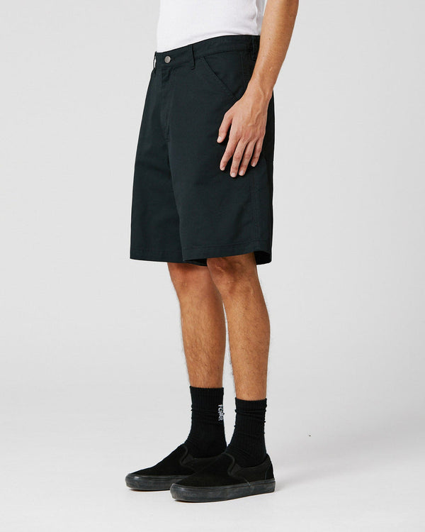 black work shorts worn side-on with relaxed fit and slip-on shoes