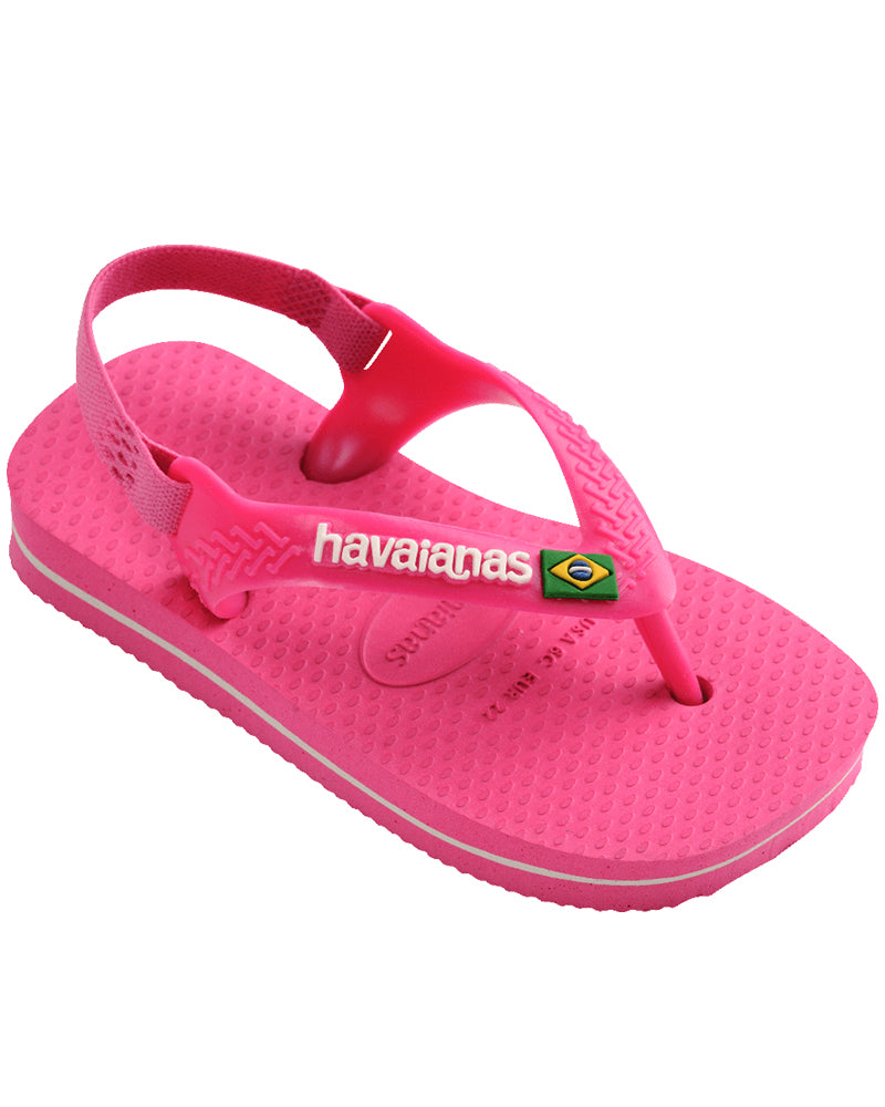 Side view of pink Havaianas baby sandal with white logo, heel strap, and textured footbed.