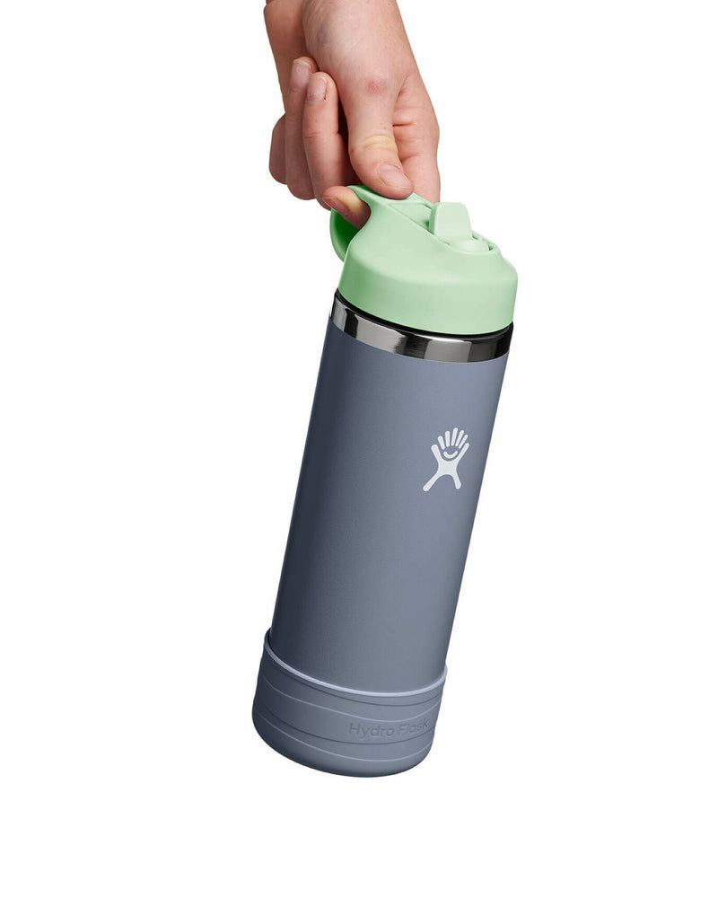 Hand holding a slate Hydro Flask with mint lid, perfect for on-the-go hydration with a secure straw and carry loop.