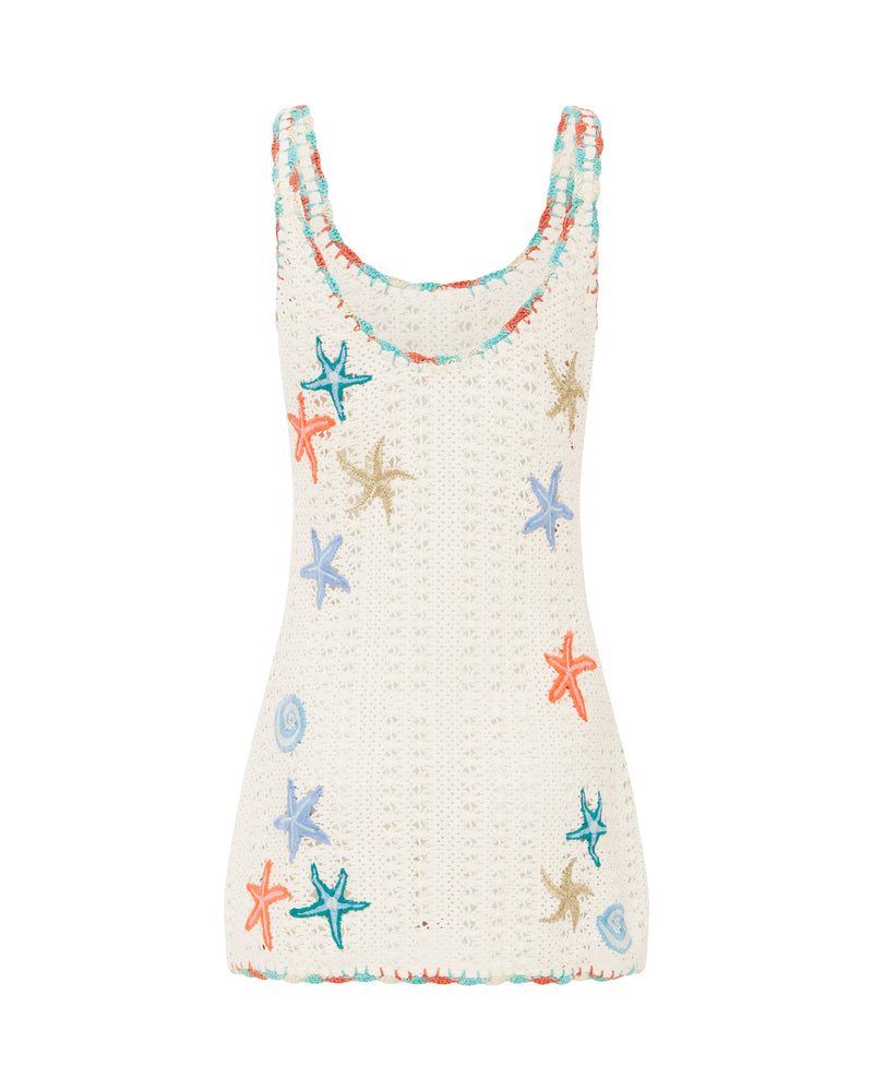 Back view of white crochet mini dress with colorful embroidered starfish and seashell details, featuring thick straps.