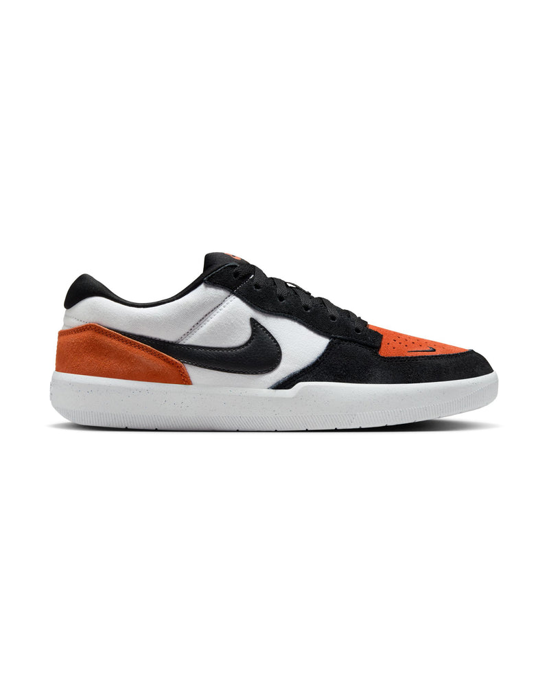 A side view of low-top sneakers featuring black, white, and orange suede panels, a black Nike swoosh, and a white rubber sole.